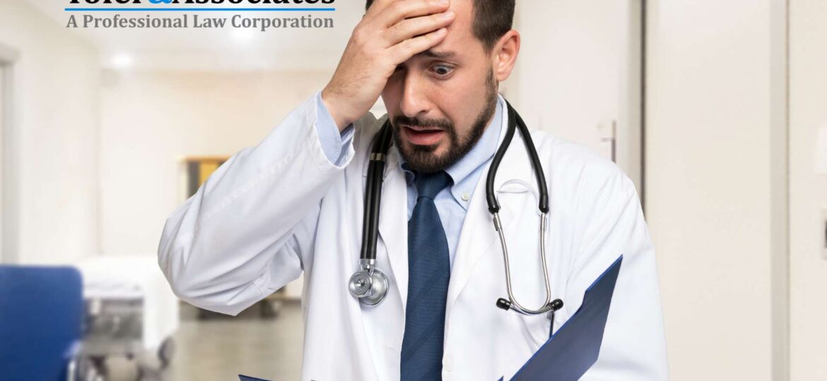 Distressed doctor holding his head while reading a wrongful death suit in California