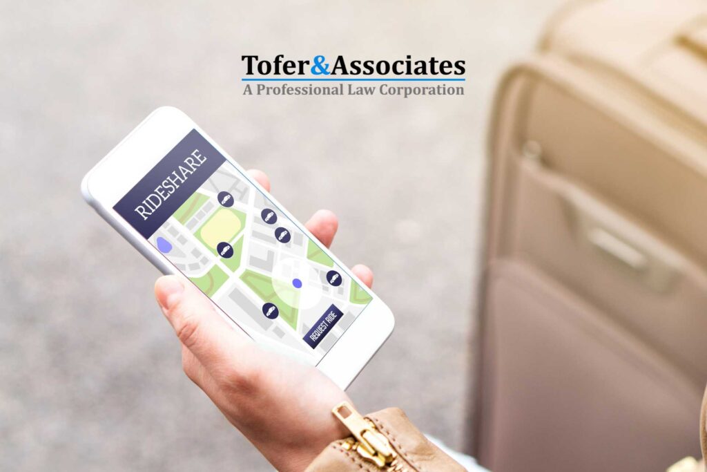 A person holds a rideshare app on their phone, waiting for an Uber, Lyft, or InDrive ride.