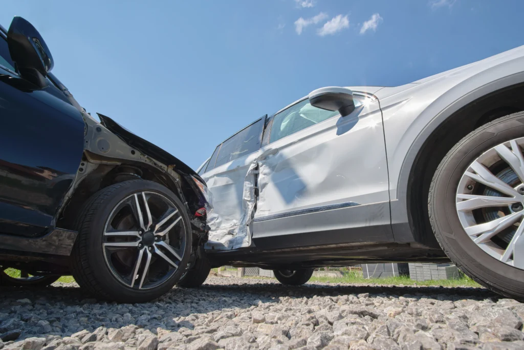 Two cars are depicted at an angle, showcasing significant damage to the passenger side of the white SUV and the front of a black vehicle.